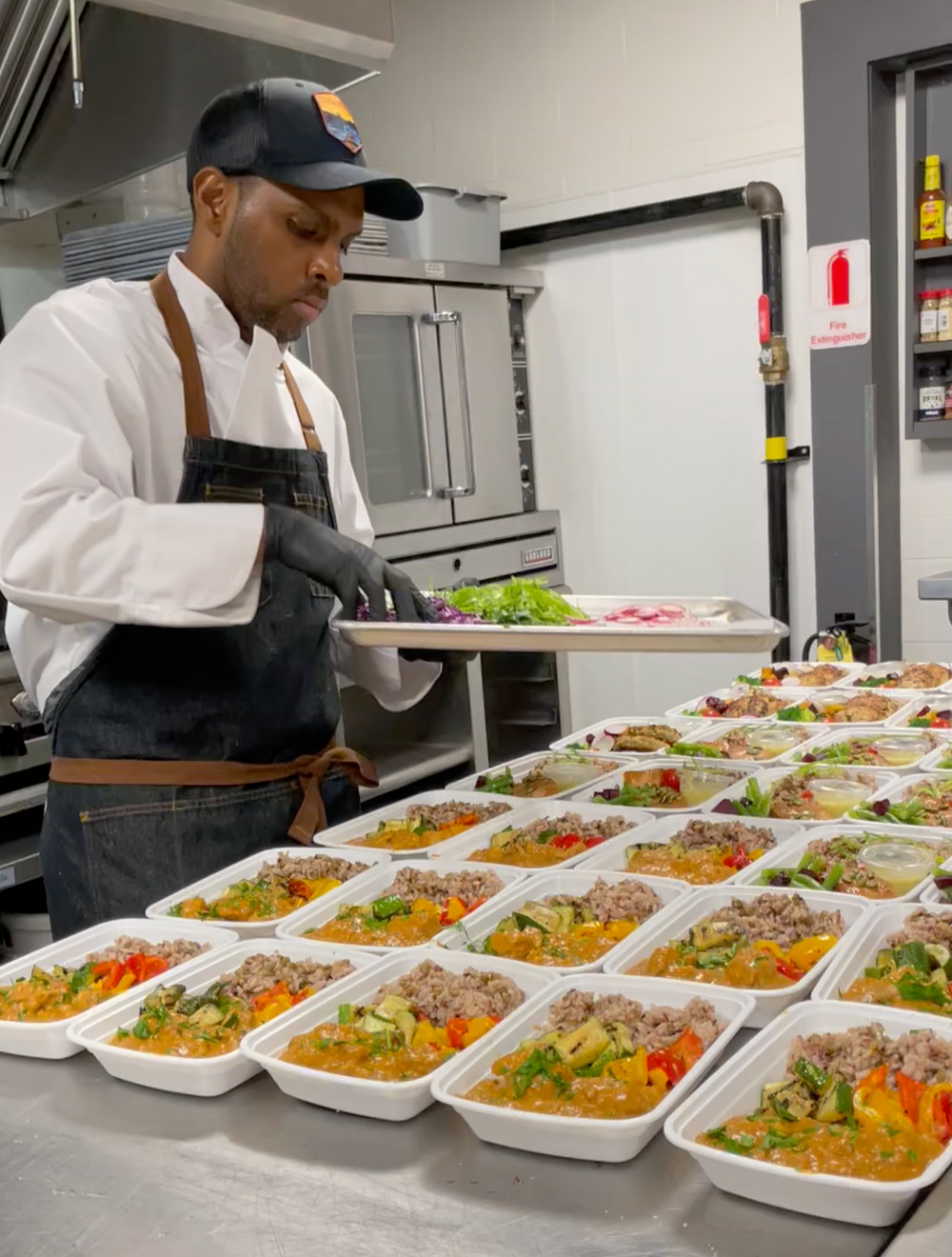 Chef preparing weekly meal prep in a commercial kitchen with fresh ingredients and small batch cooking